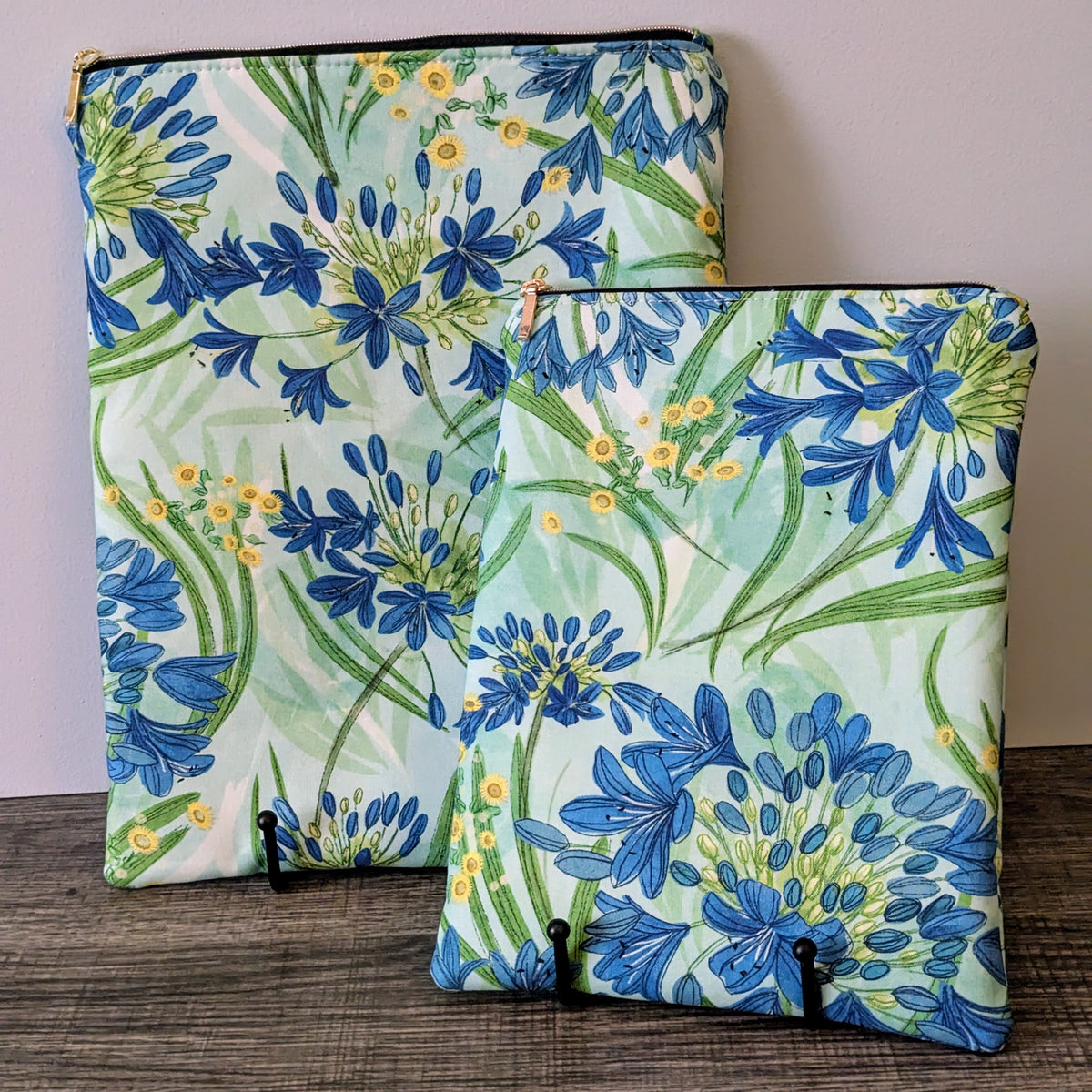 Two floral-patterned bags on a wooden surface with a neutral background