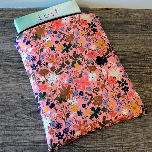 Floral-patterned pouch with 'Lost' label on a wooden surface