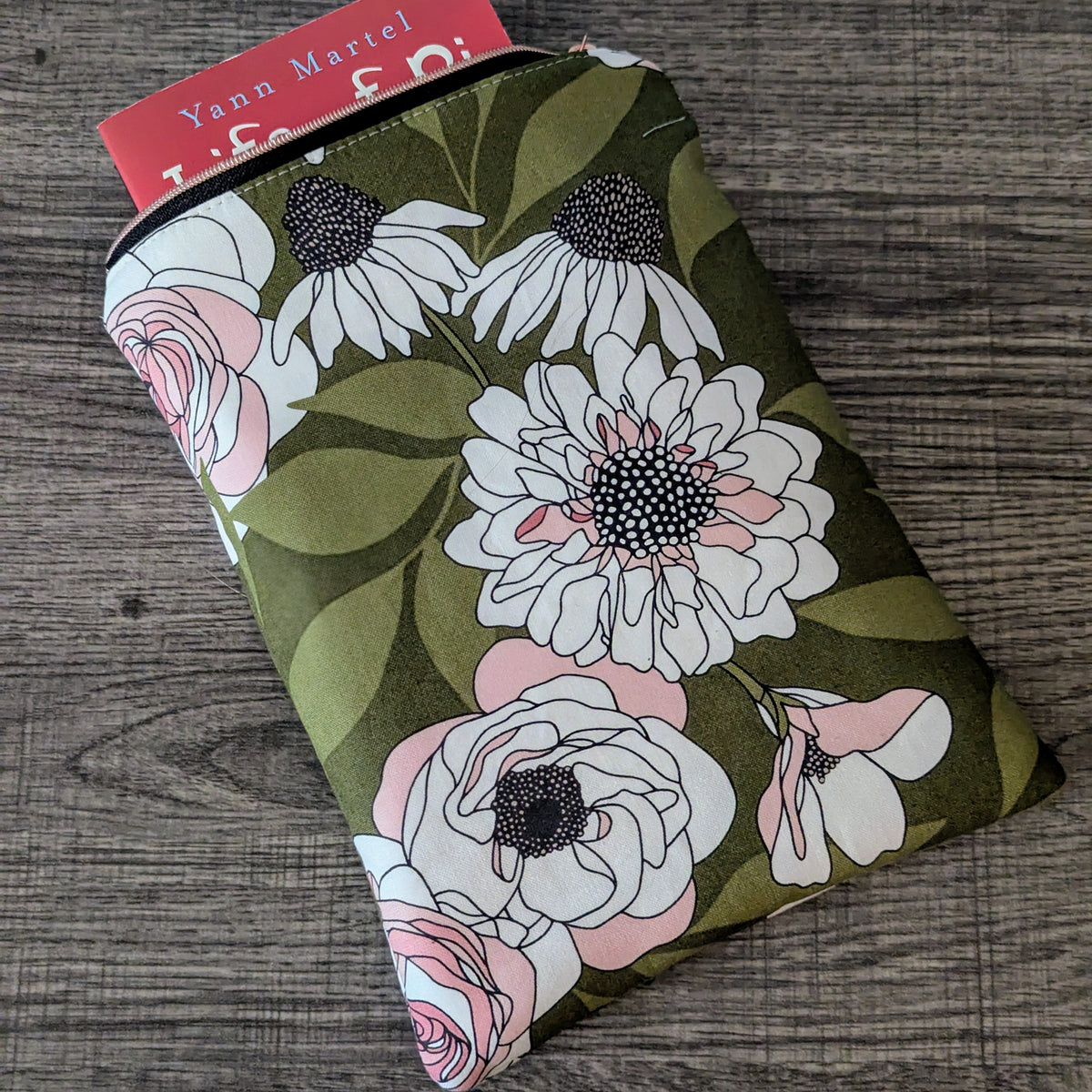 Floral pouch with a visible brand label on a wooden surface