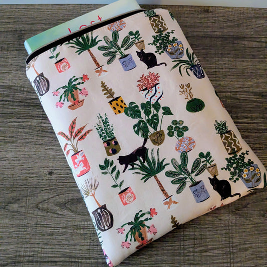 Notebook with plant and cat pattern on a wooden surface